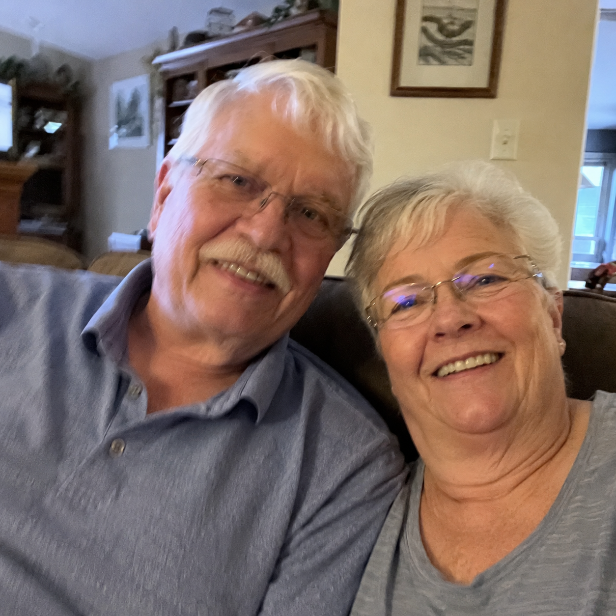 Elderly couple smiling in their living room, slightly shaky cell phone style photo